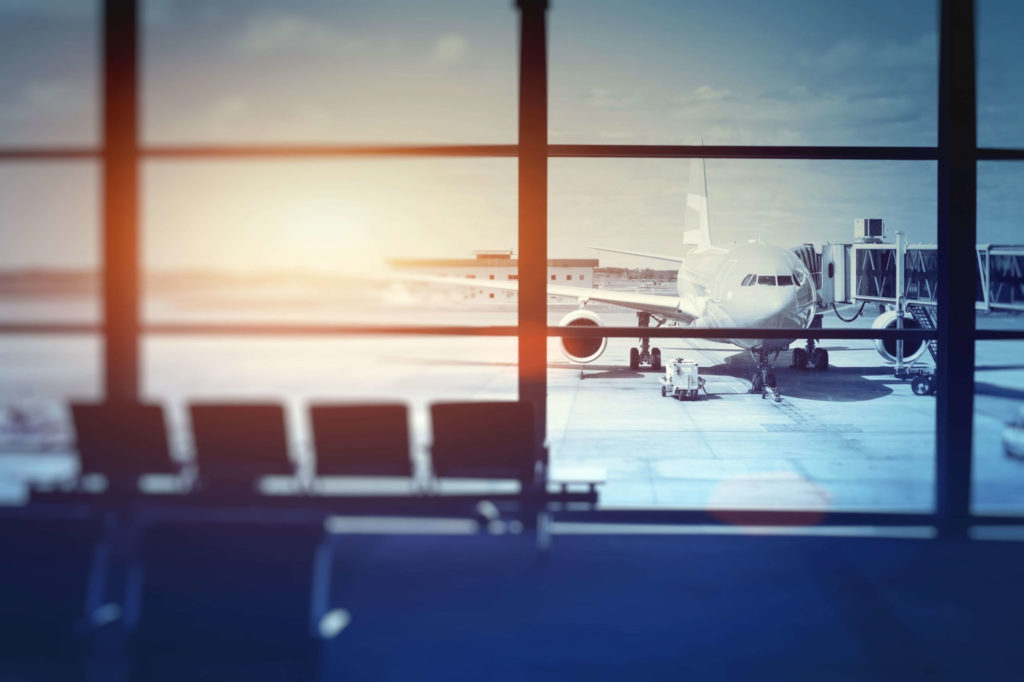 Image taken from inside of airport of outside airplane waiting for departure in airport terminal